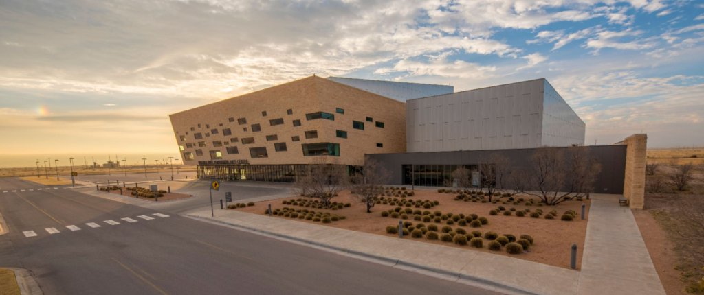 Exterior view of the Wagner Noël Performing Arts Center in Midland, Texas, at sunset, featuring its modern angular architecture and desert landscaping.